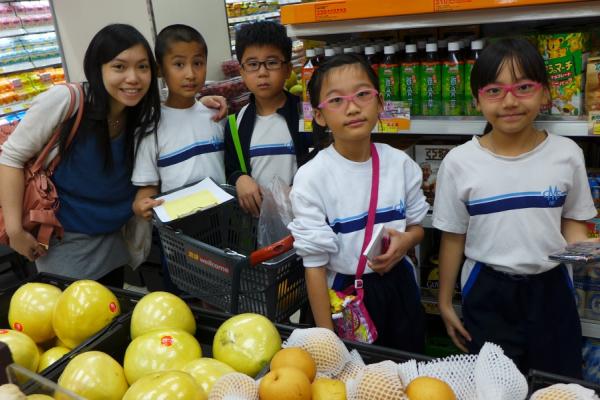 同學在超級市場內商討要購買的材料。